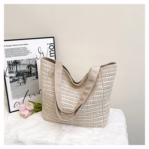 Detailed close-up of beige woven tote bag with intricate hollow patterns for summer