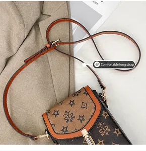 Detailed shot of a vintage crossbody phone bag with star print on a khaki blazer background