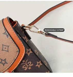 Detail of vintage monogram shoulder bag with orange leather trim and gold metal hook