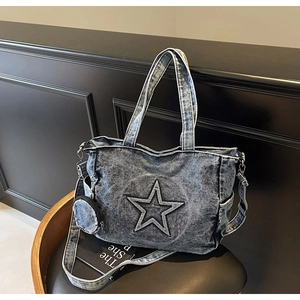 Détail du cabas en jean bleu avec écusson étoile et petite pochette ronde sur le côté