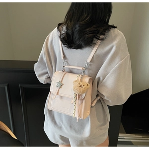 Detail of light pink mini PU leather backpack with star and plush bear charms