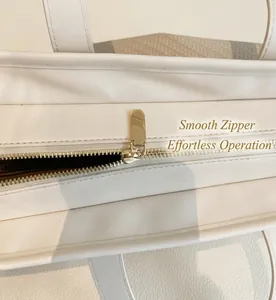 Détail de la fermeture éclair en métal doré sur un sac cabas en cuir blanc