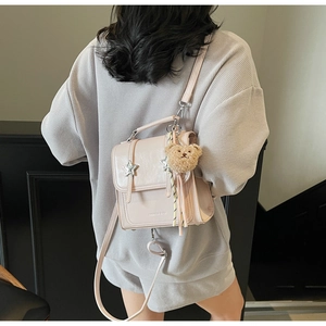 Light pink mini backpack detail with star metal decor and brown plush bear charm