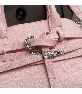 Détail de sac en cuir rose grainé litchi avec boucle métallique et lanière
