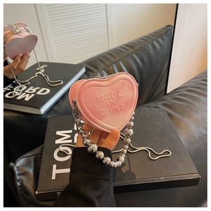 Detail of pink gradient heart bag with metallic bead handle and snake chain strap