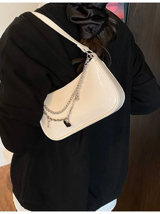 Fashionable off-white patent leather baguette bag with silver chain and heart charms