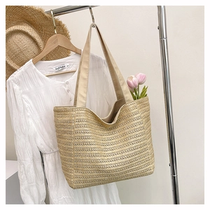 Detail of hand-woven straw tote bag hanging on a rack for a summer vacation look