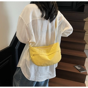 Detailed view of yellow crescent nylon crossbody bag showing the water-resistant texture