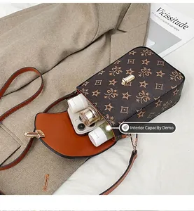 Detail view of the brown monogram crossbody bag interior showing phone and makeup storage