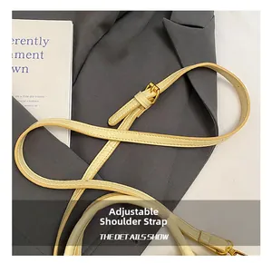 Detail of adjustable shoulder strap with crocodile pattern leather and gold metal buckle