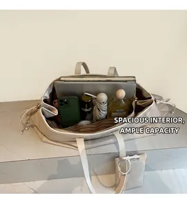 Détail de l'intérieur spacieux du cabas crème contenant un ordinateur et des livres
