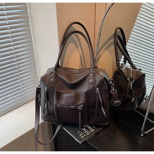 Close-up of dark brown lychee grain leather texture and functional zipper pocket detail