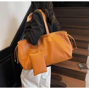 Détails du grand cabas tressé couleur caramel avec pochette assortie et cordons latéraux