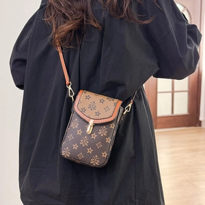 Detail of vintage brown crossbody phone bag with star monogram and gold metal buckle