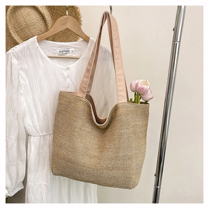Detail of a woven tote bag with pink canvas straps and spacious floral interior space