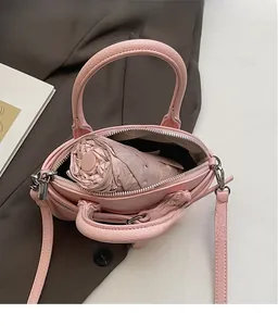 Vue intérieure du sac à main rose montrant sa capacité avec un parapluie plié