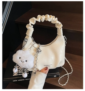 Détail du sac hobo blanc avec poignée plissée, chaîne argentée et bijou nuage