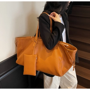 Détail du grand sac cabas tissé orange avec pochette assortie sur l'épaule d'une femme
