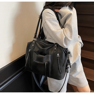 Detailed view of black litchi texture leather tote bag featuring multiple zipper pockets