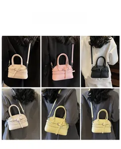 Sac bandoulière en plusieurs coloris porté par un mannequin pour un style élégant