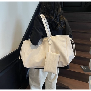 Détail du grand cabas tressé crème avec cordon latéral et petite pochette assortie