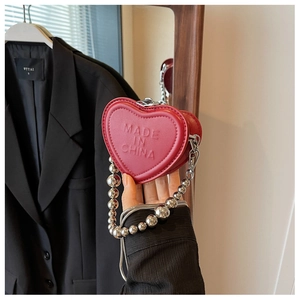 Detailed view of red heart mini bag with chunky silver beads and metal chain strap