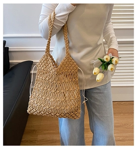 Detail of hollow-out straw beach tote featuring cotton lining and crochet flower pattern
