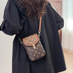 Detail view of a vintage monogram crossbody bag worn by a model in a modern room