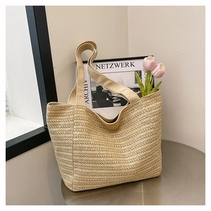 Close-up of woven paper straw tote bag with delicate wave texture on a metal table