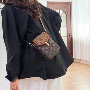 Detail of vintage monogram crossbody phone bag with metal clasp and leather strap