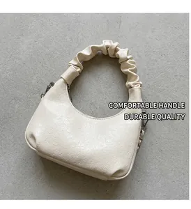 Détails de la sacoche crème avec gaufrage en cœur et poignée plissée design chic