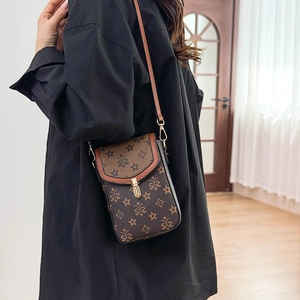Detail view of a vintage brown leather crossbody bag with starry monogram pattern