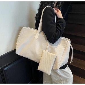 Détail d'un grand sac cabas tissé blanc crème avec texture minimaliste et anses en cuir