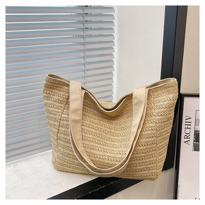 Detailed macro shot of fine beige straw weaving and white canvas strap on a summer tote