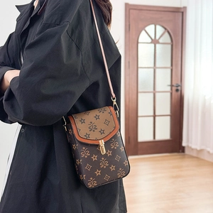Side view of a vintage vertical brown crossbody bag with gold buckle on a model