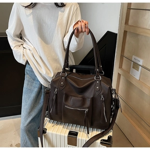 Detailed macro view of large brown lychee-patterned tote bag with silver hardware accents