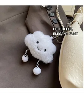 Gros plan du porte-clés nuage en peluche blanc avec broderie sur un sac à main