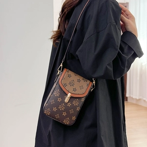 Close-up of retro monogram crossbody bag with brown leather pattern and gold buckle