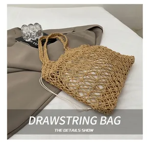 Detail of hollow woven cotton tote bag with a white drawstring inner pouch on grey fabric