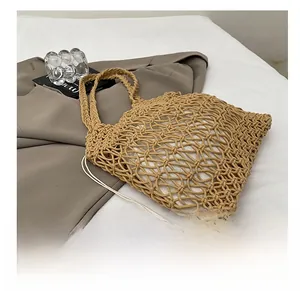 Detail of hollow woven cotton tote bag with a white drawstring inner pouch on grey fabric