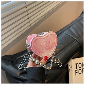 Detail of pink heart-shaped mini bag featuring gradient PU leather and silver bead handle