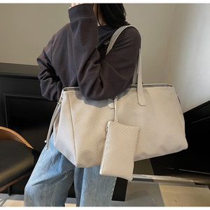 Détail d'un grand sac cabas avec texture tressée et pochette sur mannequin mode