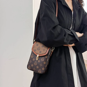 Detailed view of a vintage crossbody phone bag with star patterns and gold metal lock