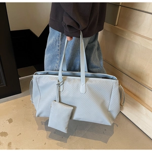 Détail du grand sac cabas bleu clair tressé avec pochette assortie et cordon de serrage