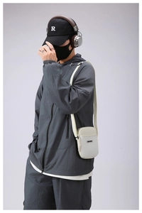 Detail of a white crossbody bag with grid texture on a model in urban techwear style