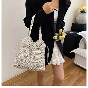 Detail of hollow woven cotton mesh shoulder bag with braided handle and drawstring accents