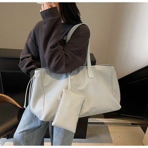 Détail du grand sac cabas tressé bleu clair avec pochette assortie et cordon de serrage