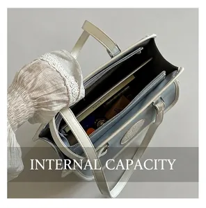 Détail de la grande capacité intérieure et du compartiment zippé du sac en cuir bleu clair