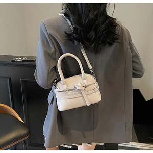 Détail d'un sac coquillage crème avec texture grainée et bandoulière réglable
