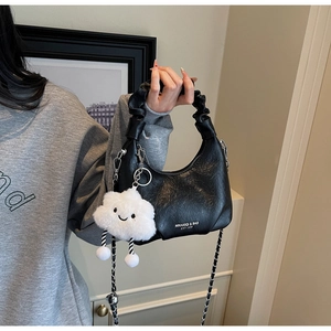 Détail du sac demi-lune noir avec bandoulière chaîne et pendentif nuage en peluche blanc